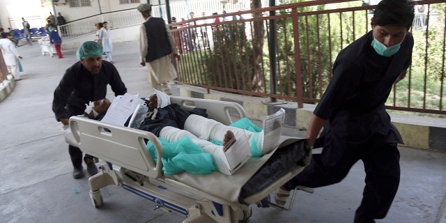 An injured man is carried into a hospital after a car bomb explosion in Kabul, Afghanistan, Thursday