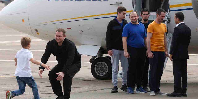 Ukraine's President Volodymyr Zelenskiy, right, greets Ukrainian prisoners upon their arrival at Boryspil airport, outside Kyiv, Ukraine, Saturday, Sept. 7, 2019.