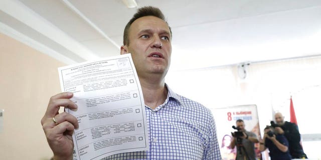Alexei Navalny shows his ballot as he arrives to vote during a city council election in Moscow on Sunday