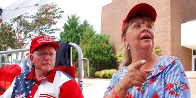 Philip Ezzell, left, and his wife, Diane Ezzell, from Marshville, N.C., talk about why they support President Trump as they wait in line to enter his latest rally on Monday. (AP Photo/Chris Seward)