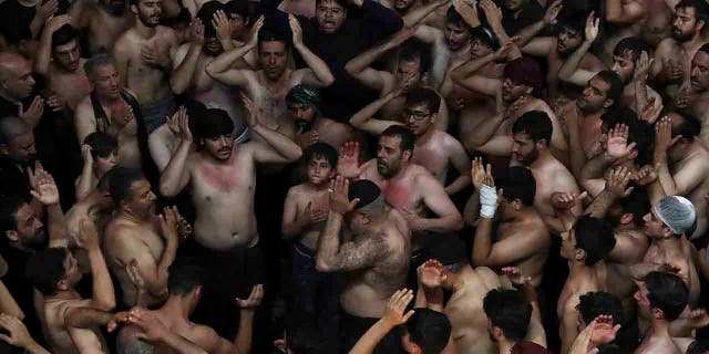 Iranian and Iraqi Shiite Muslims beat their heads during a mourning ceremony marking Ashoura in downtown Tehran, Iran, Tuesday, Sept. 10, 2019.