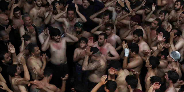 Iranian and Iraqi Shiite Muslims beat their heads during a mourning ceremony marking Ashoura in downtown Tehran, Iran, Tuesday, Sept. 10, 2019. 