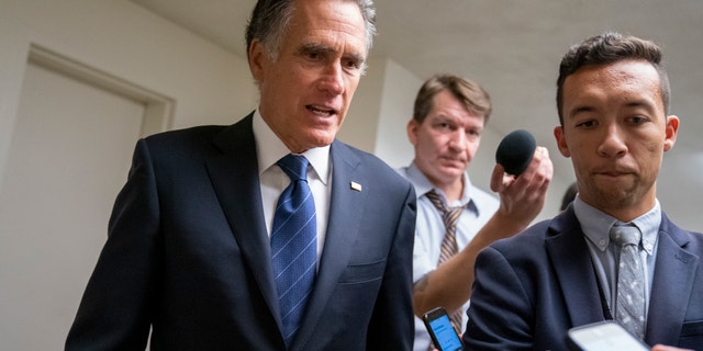 Sen. Mitt Romney, R-Utah, takes questions from reporters as he arrives for votes on pending nominations, at the Capitol in Washington, Wednesday, Sept. 11, 2019.
