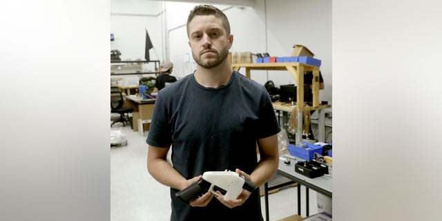 Cody Wilson holds a 3D-printed gun called the Liberator at his shop in Austin, Texas, last year. (AP Photo/Eric Gay, File)