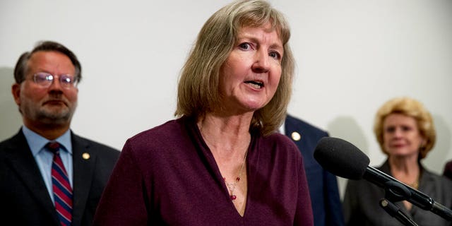 Elizabeth Whelan, the sister of Paul Whelan, accompanied by Sen. Gary Peters., D-Mich., and Sen. Debbie Stabenow, D-Mich., speaks at a news conference Thursday. (AP Photo/Andrew Harnik)