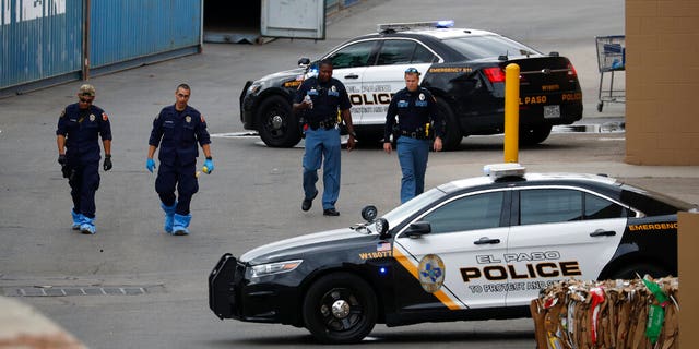 In this Aug. 6, 2019, file photo, police officers walk behind a Walmart at the scene of a mass shooting at a shopping complex in El Paso, Texas. Patrick Crusius, 21, was indicted Thursday, Sept. 12, 2019, for capital murder in connection with the Aug. 3 mass shooting that left 22 dead. He is jailed without bond.