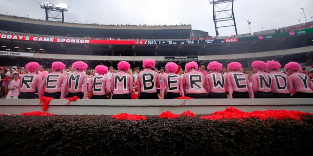 Georgia fans observe a moment of silence in horror of Wendy Anderson, wife of Arkansas State head coach Blake Anderson before an NCAA college football game Saturday, Sept. 14, 2019, in Athens, Ga. Fans were encouraged to "pink out" the stadium for Wendy Anderson who died from breast cancer in August. (AP Photo/John Bazemore)