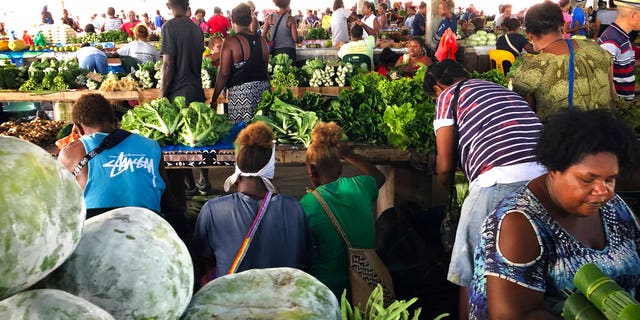 Customers shop for vegetables at the Honiara Central Market in Honiara, the capital of the Solomon Islands.