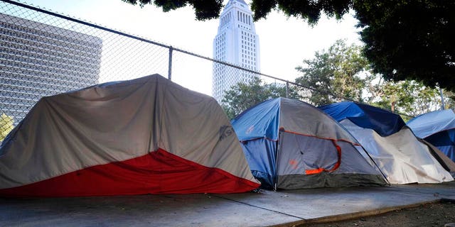 Los Angeles City Hall is behind a homeless tent camp on a street in downtown Los Angeles this past July. (AP Photo / Richard Vogel, File)