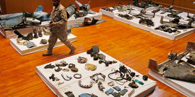 A Saudi military officer walks by what was described asa the remains of Iranian cruise missiles and drones used in an attack this weekend that targeted the heart of Saudi Arabia's oil industry, during a press conference by military spokesman Col. Turki al-Malki in Riyadh, Saudi Arabia, Wednesday, Sept. 18, 2019. Though Yemen's Houthi rebels claimed the assault, the U.S. alleges Iran was behind it. (AP Photo/Amr Nabil)
