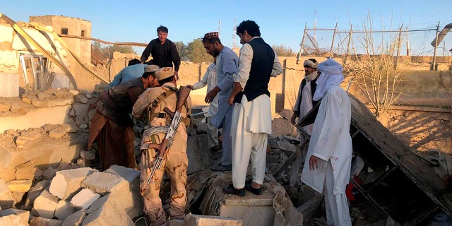 Afghan security members and people work at the site of a suicide attack in Zabul, Afghanistan, Thursday, Sept. 19, 2019. A powerful early morning suicide truck bomb devastated a hospital in southern Afghanistan on Thursday. (AP Photo/Ahmad Wali Sarhadi)