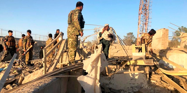 Afghan security members and people work at the site of a suicide attack in Zabul, Afghanistan, Thursday, Sept. 19, 2019. A powerful early morning suicide truck bomb devastated a hospital in southern Afghanistan on Thursday. (AP Photo/Ahmad Wali Sarhadi)