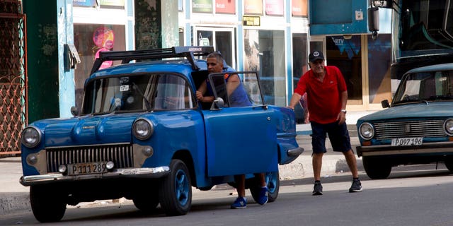 A drives pushes his vehicle to a gas station in Havana, Cuba, Thursday, Sept. 19. Increasingly, gas stations are running out with people still waiting in line.