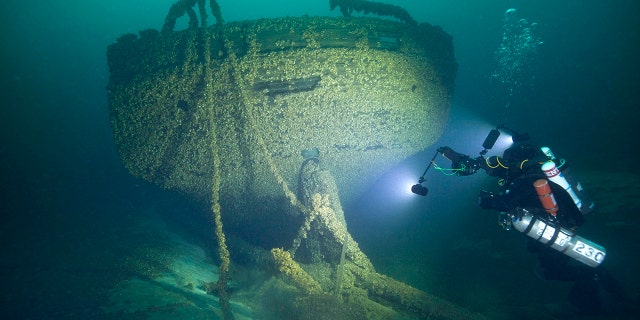 In this Aug. 24, 2019, photo provided by John Janzen, diver John Scoles maneuvers around the wreckage of the schooners Peshtigo and St. Andrews, lost in 1878 near Beaver Island in northern Lake Michigan. A group of maritime history enthusiasts led by Boyne City, Michigan diver and explorer, Bernie Hellstrom have announced the discovery of the schooners. The site was located in 2010 by Hellstrom during one of his many trips to explore the Beaver Island archipelago.
