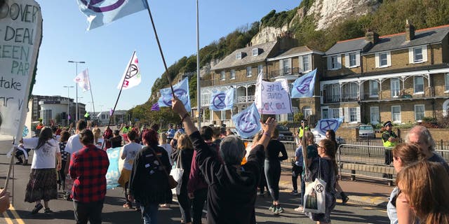 Extinction Rebellion protesters occupy one side of a dual carriageway at the port of Dover, England, Saturday Sept. 21, 2019. Traffic around the Port of Dover, England's major sea connection with France, has been disrupted as a result of a protest by environmental activists. Activists from Extinction Rebellion said their protest around the port is intended to "highlight the vulnerability of the U.K.'s food supply in the face of the ecological and climate emergency." (Michael Drummond/PA via AP)