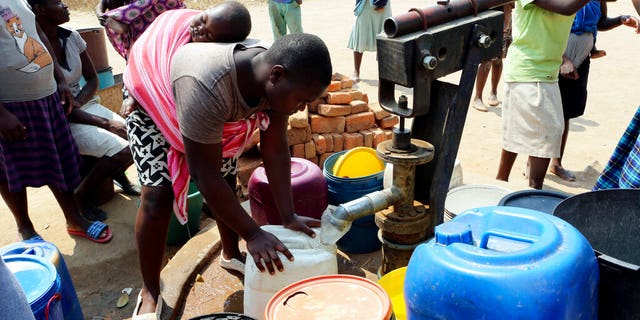 Residents of Epworth wait to fetch water at a borehole in Harare, Tuesday, Sept, 24, 2019.