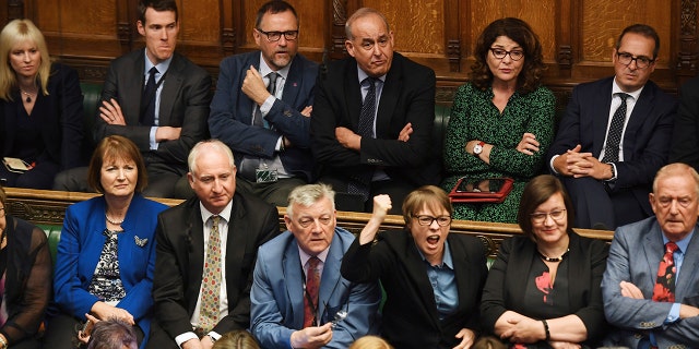 In this handout photo provided by the House of Commons, opposition MP's look on as Britain's General Attorney Geoffrey Cox speaks in Parliament in London, Wednesday, Sept. 25, 2019.