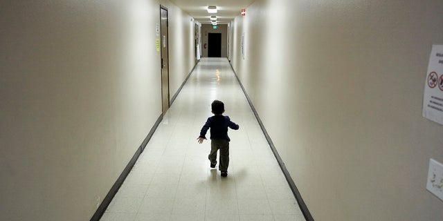 In this Dec. 11, 2018, photo, an asylum-seeking boy from Central America runs down a hallway after arriving at a San Diego, Calif., shelter from an immigration detention center (AP Photo/Gregory Bull, File)