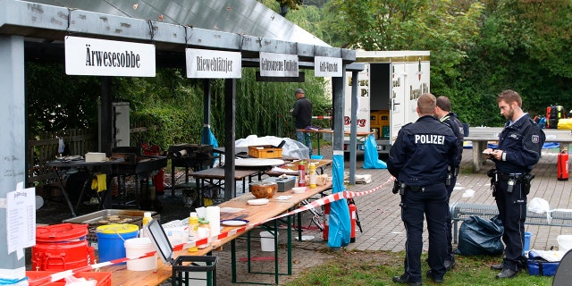 In this Sunday, Sept. 8, 2019 photo police officers investigate a booth after an explosion at a village festival in Freudenberg, Germany.