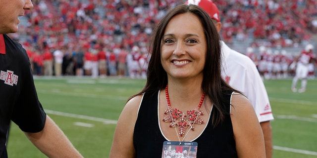 Wendy Anderson, center, wife of Arkansas State head coach Blake Anderson, obscured at left, smiles after chatting with Nebraska head coach Mike Riley, rear, before an NCAA college football game in Lincoln, Neb., in 2017. Wendy Anderson died on Aug. 19 after a two-year fight with breast cancer. He said on Twitter: "She passed as peacefully & gracefully as you could ever hope." (AP Photo/Nati Harnik, File)