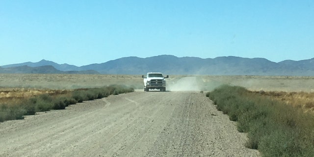 An unmarked white truck turns from a side road onto the roadway to Area 51's so-called "back gate" on Sept. 18, 2019.