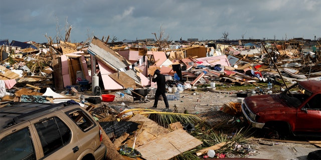 A man walks among debris at the Mudd neighborhood, devastated after Hurricane Dorian hit the Abaco Islands in Marsh Harbour, Bahamas, September 6, 2019. (REUTERS/Marco Bello)