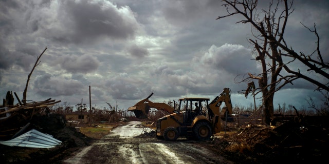 Mos Antenor, 42, drives a bulldozer while clearing the road after Hurricane Dorian Mclean's Town, Grand Bahama, Bahamas, Friday Sept. 13, 2019.