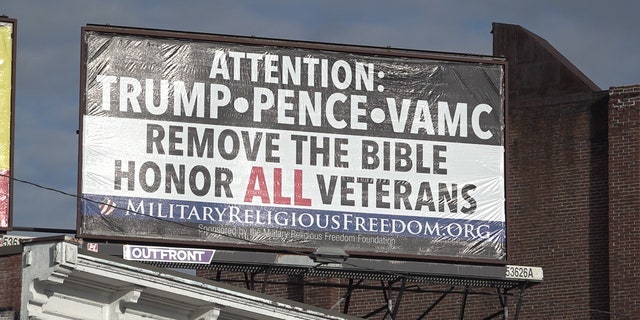 A billboard calling on President Trump, Vice President Pence, and the VA to take the Bible out of the hospital on display in downtown Manchester, N.H.  