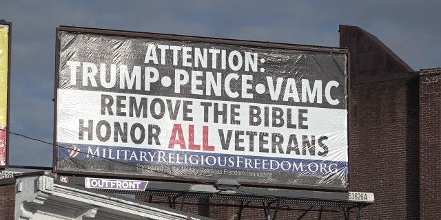 A billboard calling on President Trump, Vice President Pence, and the VA to take the Bible out of the hospital on display in downtown Manchester, N.H.  