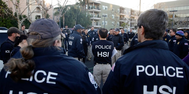 Federal agents gathering at a parking lot before raiding an upscale apartment complex linked to a birth tourism business in Irvine, Calif., in 2015.