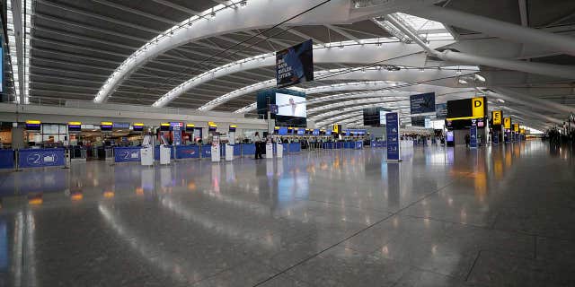 Terminal 5 at Heathrow Airport, which handles British Airways flights, stands virtually empty of passengers as staff on Monday morning.