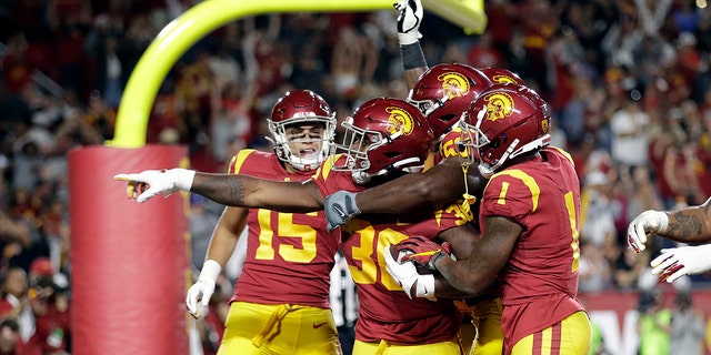 Southern California running back Markese Stepp, second from left, points after rushing for a touchdown against Utah during the second half of an NCAA college football game Friday, Sept. 20, 2019, in Los Angeles.