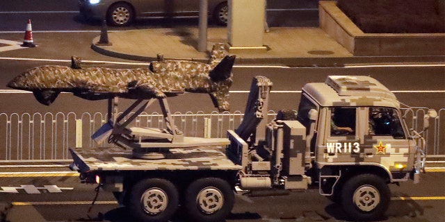 A Chinese military vehicle carrying what appears to be a drone passing along the Jianguomenwai Avenue during a rehearsal last weekend for the 70th anniversary of Communist China, in Beijing. (AP Photo/Mark Schiefelbein)