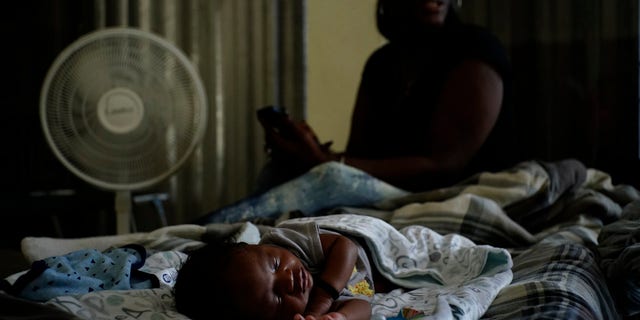 A baby sleeps inside a church that was opened up as a shelter for residents who will wait out Hurricane Dorian in Freeport on Grand Bahama, Bahamas, Sunday, Sept. 1, 2019.