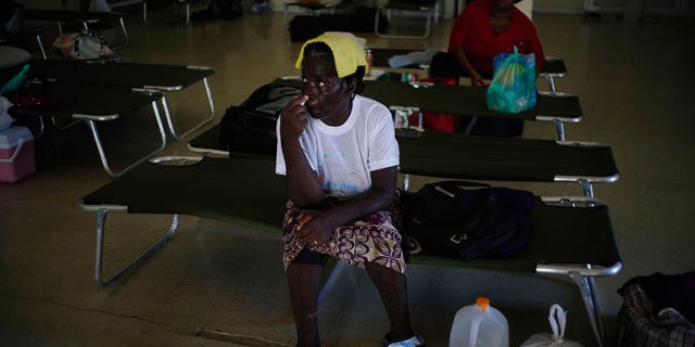 Women sit on cots inside a church now serving as a shelter for residents who will wait out Hurricane Dorian in Freeport on Grand Bahama, Bahamas, Sunday, Sept. 1, 2019.