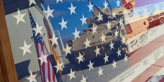An encased flag is displayed during a ceremony at the 1st Battalion, 37th Armored Regiment, 2nd Armored Brigade Combat Team, 1st Armored Division motor pool. (U.S. Army photo by: Sgt. Michael West/2nd ABCT, 1st AD Public Affairs)