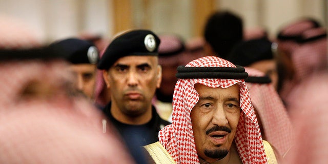 Saudi Arabia's King Salman is guarded by his bodyguard.