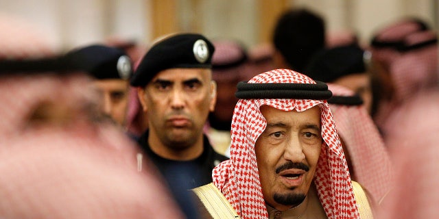 Saudi Arabia's King Salman is guarded by his bodyguard.