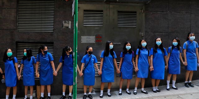 Students wearing mask hold hands to surround St. Stephen's Girls' College in Hong Kong, Monday, Sept. 9, 2019. (AP Photo/Kin Cheung)