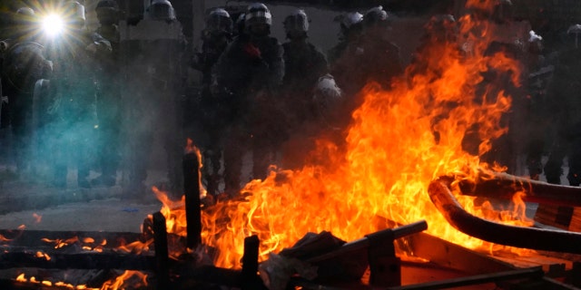 Police face a burning barricade during protests in Hong Kong on Saturday, Sept. 21, 2019. Protesters in Hong Kong burned a Chinese flag and police fired pepper spray Saturday in renewed clashes over grievances by the anti-government demonstrators. (AP Photo/Vincent Yu)