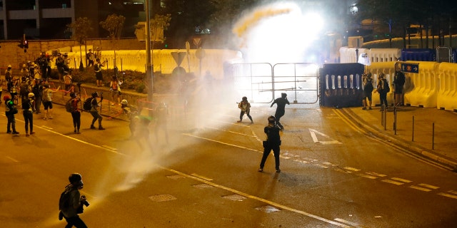 Police fire water cannon on protestors in Hong Kong Saturday. (AP Photo/Vincent Thian)