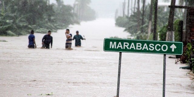 Residents wade through a flooded road during rain storm caused by Tropical Storm Lorena on the outskirts of Manzanillo, in Colima state, Mexico September 19, 2019.