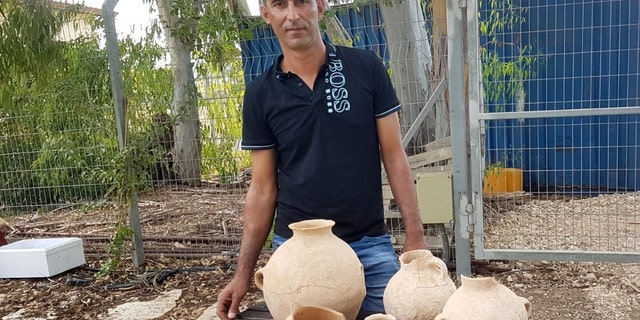 Ahmed Nassar Yassin and the artifacts. (Nir Distelfeld, Israel Antiquities Authority)