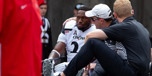 Cincinnati Bearcats safety Kyriq McDonald #26 is carted off the field after an injury during game action between the Ohio State Buckeyes and the Cincinnati Bearcats on Saturday in Columbus, Ohio.. (Photo by Adam Lacy/Icon Sportswire via Getty Images)