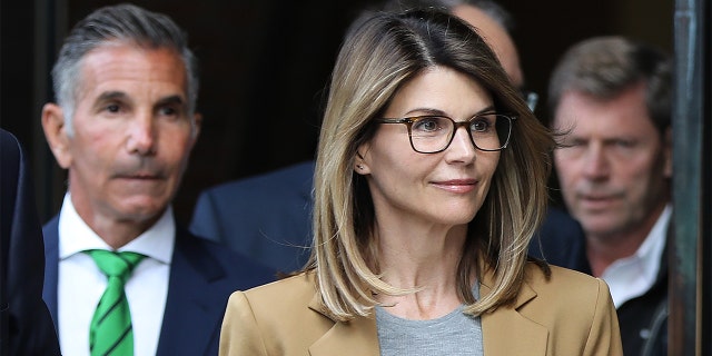 La actriz Lori Loughlin y su esposo Mossimo Giannulli, vistiendo una corbata verde a la izquierda, abandonan la Corte de Justicia de los Estados Unidos John Joseph Moakley de los Estados Unidos en Boston el 3 de abril de 2019. Loughlin y Giannulli se declaran culpables de pagar sobornos para que sus hijas ser admitido en la Universidad del Sur de California.