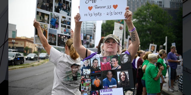 In this archive photo from August 17, 2018, Lynn Wencus, of Wrentham, Mass., Holds a sign with a picture of her son Jeff and bears a trace of loved ones lost to OxyContin and to other opioids during a demonstration at Purdue Pharma LLP Headquarters in Stamford, Connecticut (Photo AP / Jessica Hill, File)