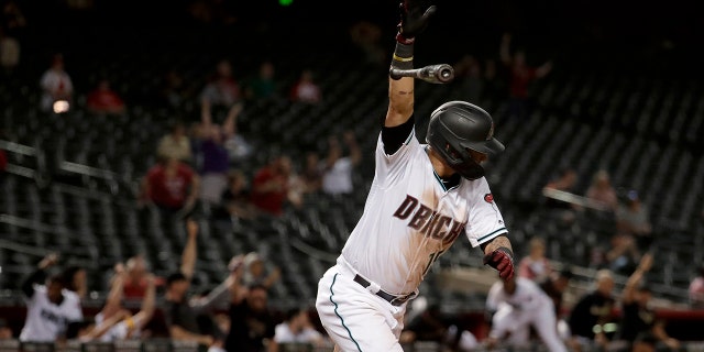 Arizona Diamondbacks' Ildemaro Vargas celebrates his walk off base hit against the St. Louis Cardinals as teammates run out of the dugout during the 19th inning, Wednesday, Sept. 25, 2019, in Phoenix. The Diamondbacks won 3-2. (AP Photo/Matt York)