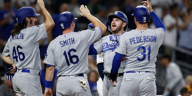 Los Angeles Dodgers' Max Muncy, second from right, greets teammates Tony Gonsolin (46), Will Smith (16), and Joc Pederson (31), after hitting a grand slam during the fourth inning of a baseball game against the San Diego Padres Tuesday, Sept. 24, 2019, in San Diego. (AP Photo/Gregory Bull)