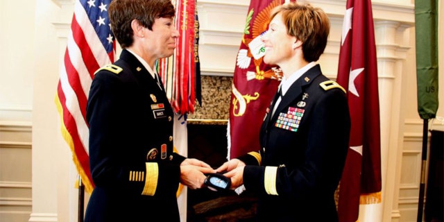 Maj. Gen. Maria Barrett presenting Brig. Gen. Paula Lodi a beret with one-star rank insignia as a tribute to the history of women serving in the Army and the historic moment of sisters serving together as General Officers.