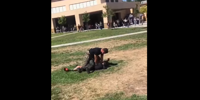 A U.S. Marine held down two high school students in Stockton, Calif., after tackling them to break up their fight. (Courtesy of 209 Times)